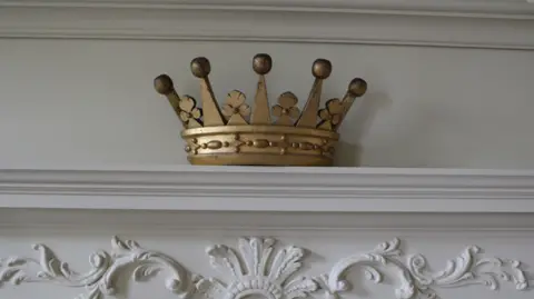 National Trust A gold crown on a mantlepiece 
