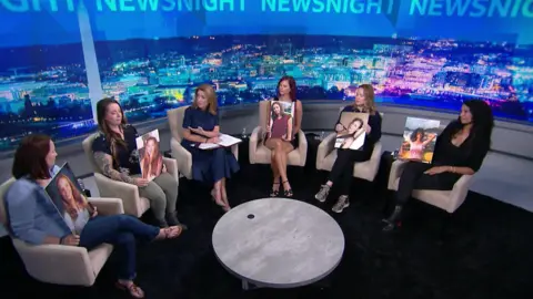 Five Epstein survivors sit on chairs holding pictures of their younger selves while being interviewed by Victoria Derbyshire, who is also sitting with them, on a BBC Newsnight TV studio set.