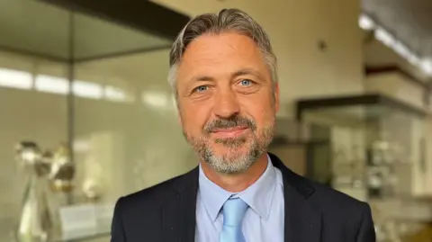 A man with a beard in a suit and jacket