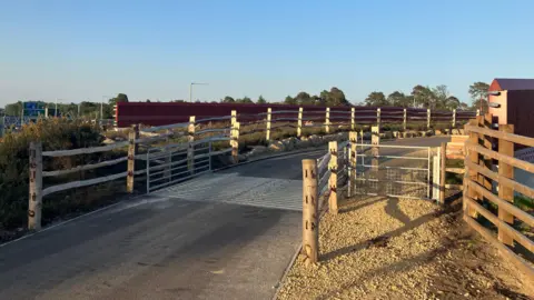 A concrete road with wooden gates. 