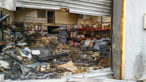 Metropolitan Police An image underneath a metal shutter shows a burnt out warehouse