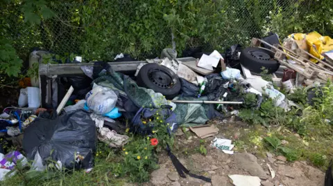 Facundo Arrizabalaga Rubbish including tyres, bags and household waste dumped on land next to Sutton Station before the clean-up.