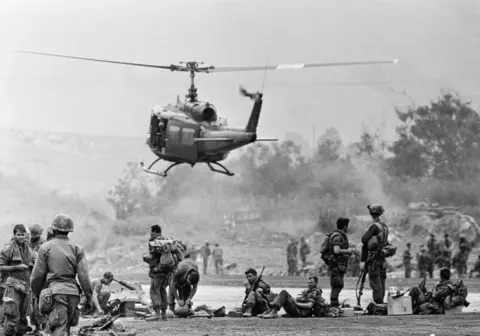 Getty Images helicopter hover over the soldiers in the Vietnamese jungle. 