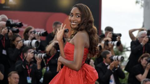 US actor Ayo Edebiri wearing red dress and waving