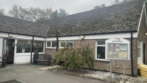 An image of Woodlands Home for Older People. It is a single-storey brick building.