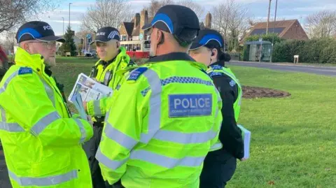 George Torr/BBC Four PCSOs in hi-vis jackets with leaflets.