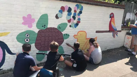 NR5 Community Hub/ Facebook Children painting a mural on a wall