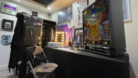 Replica of Lemmy's dressing room, including a mobile gaming machine, his dressing gown, hat, coat and boots