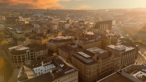 An aerial view of a part of Bradford known as Little Germany, which has lots of large Victorian industrial buildings, taken at sunrise 