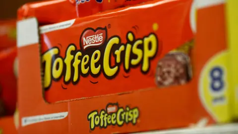 Getty Images A close-up image of a bright orange box of Nestle Toffee Crisp bars on display in a shop