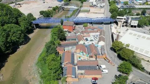 Bristol Animal Rescue Centre A drone shot of the Bristol Animal Rescue Centre site. There are buildings in the middle and a river to the right. In the top right of the image is a blue bridge.