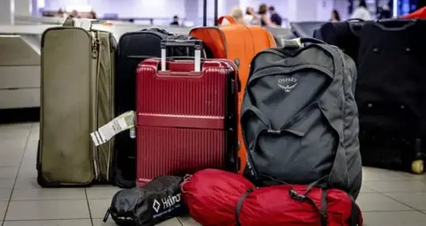 Getty Images A pile of bags, of various sizes and colours are on the floor of an airport terminal.