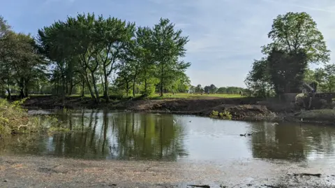  Serpentine Lake in Preston's Moor Park on a sunny day.