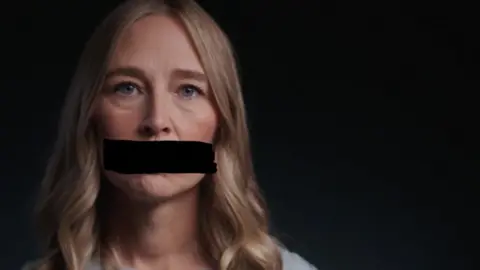 A survivor of Jeffrey's Epstein's abuse looks at the camera and appears with a black redaction mark across her mouth