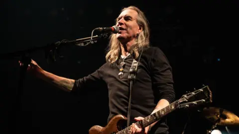 Getty Images New Model Army singer Justin Sullivan singing with an electric guitar