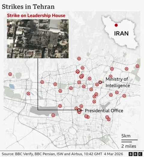 A detailed street‑map of Tehran showing several locations marked with red explosion‑style icons indicating strike sites. In the northern part of the city, one marker sits at the Ministry of Intelligence. Farther south, a cluster of markers indicates multiple strikes near the Presidential Office. To the east, there is another individual strike marker. A box in the upper left shows a satellite close‑up labelled “Strike on Leadership House,” depicting a damaged compound with dark blast marks and surrounding buildings