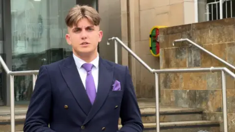George Finch stood at the council house steps wearing a navy suit and purple tie