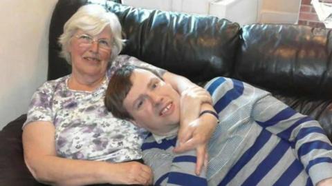 Anna Froud hugging her son Gordon Froud on a sofa - both are smiling 