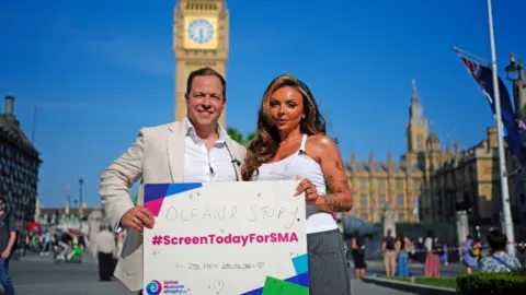 Giles Lomax, CEO for SMA UK (left) and former Little Mix singer Jesy Nelson (right) in Parliament Square, London