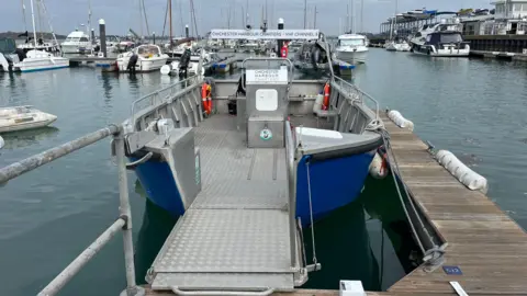 George Carden/BBC The boat docked up at Sparkes Marina at Hayling Island with its front ramp down for passengers to get on