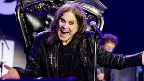 Ross Halfin Ozzy Osbourne on stage with his arms outstretched and smiling