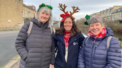 Charles Heslett/BBC Three woman with one wearing brown fake antlers by the side of a canal