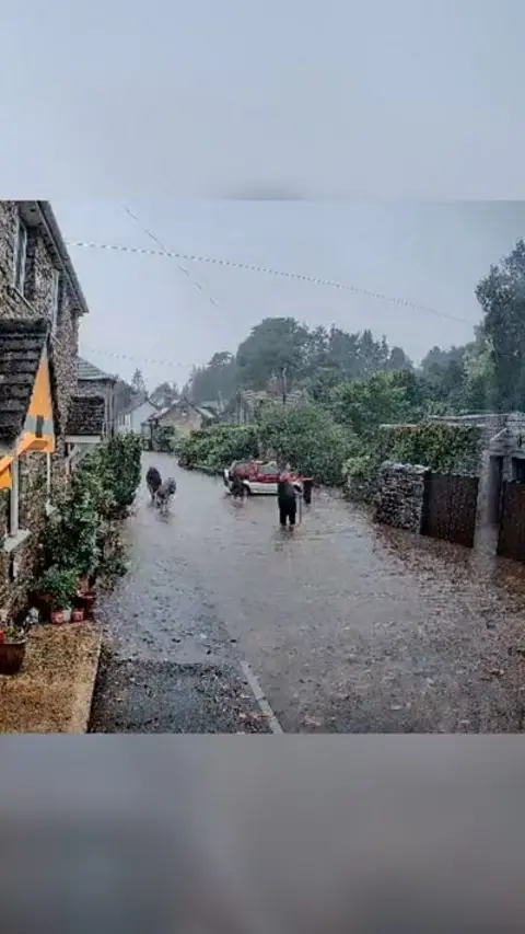 People standing in flash flooding in a village. 