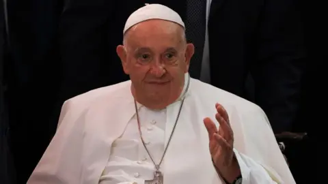 EPA Late Pope Francis smiling and with the left hand raised in front of his chest