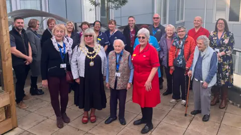 Somerset NHS Foundation Trust A group of people is standing together looking at the camera. They are all smiling.