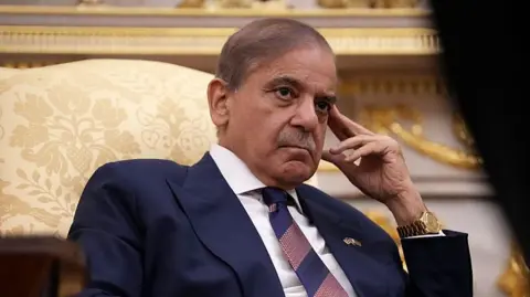 Prime Minister of Pakistan Shehbaz Sharif looks on as US President Donald Trump speaks to reporters in the Oval Office of the White House on September 25, 2025.