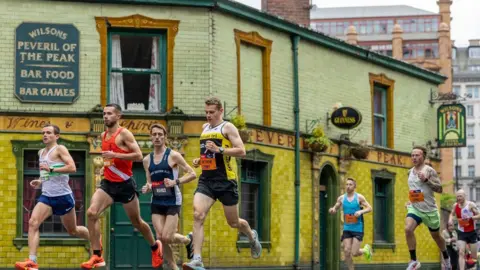 Great Manchester Run Runners go past the Peveril Of The Peak pub