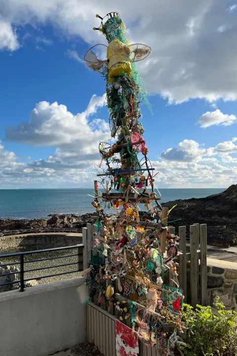 The Vive La Vallette Christmas Tree in full. The 'angel' on the top is made from an old snorkel mask. The sea is in the background.