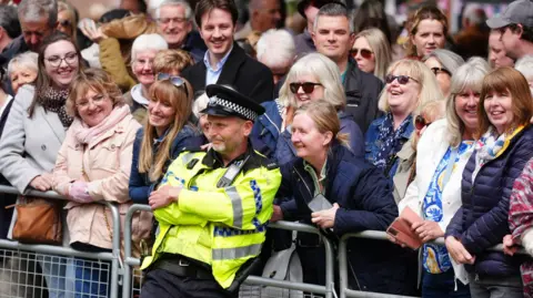 PA Media A police officer leans into a crowd of well-wishers at the wedding of the Duke of Westminster in Chester