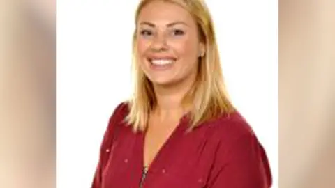 BBC A woman smiling at the camera. It is a head and shoulders shot. She has blonde hair and a red top on.