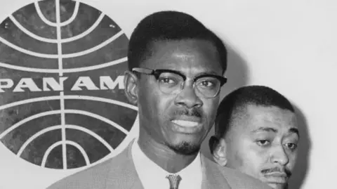 Patrice Lumumba, dressed in a suit, speaks at John F. Kennedy International Airport, New York, on 2 August 1960