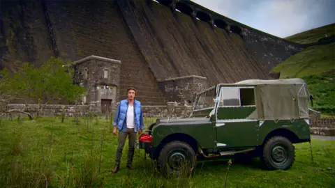 Former Top Gear presenter Richard Hammond with a green Land Rover in front of Clearwen Dam 