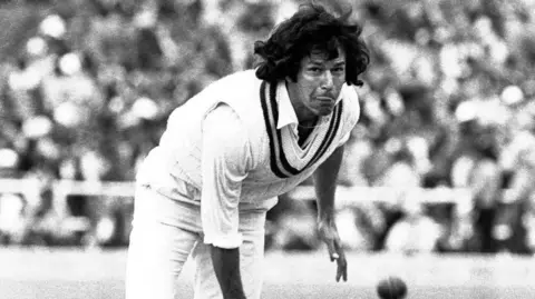 Getty Images Imran Khan bowling. He is in cricket whites and has long black hair.