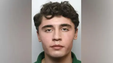 MET Police A mugshot of Daniel Khalife, who has curly dark hair and wears a green shirt.