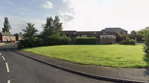 Google Street View image of Foundry Mill Mount in Seacroft, a large grassy area with buildings in the background.