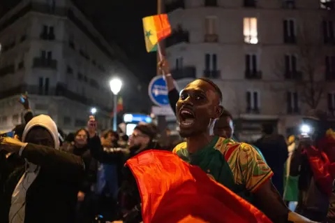 NurPhoto via Getty Images Senegal football supporters celebrate on Boulevard Barbes, at Chateau Rouge.