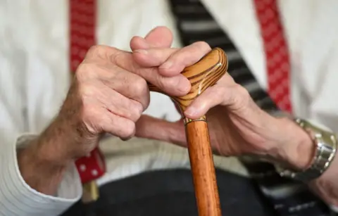 PA Media Generic photo of an elderly man's hands holding stick