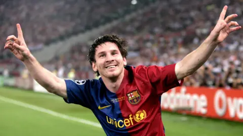 European Pressphoto Agency Lionel Messi points to the sky after scoring in a UEFA Champions League final. The FC Barcelona kit is half red and half blue. It has Unicef written in yellow in the centre.