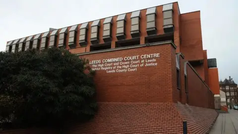 PA Media Leeds Crown Court, a redbrick building with a sign indicating its use.