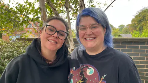 Jodie and Lucy standing side by side with a smile on their faces