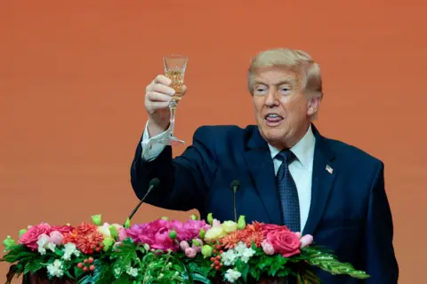Reuters U.S. President Donald Trump raises a glass with a drink as he speaks at a state banquet with Chinese President Xi Jinping (not pictured) at the Great Hall of the People in Beijing, China, May 14, 2026.