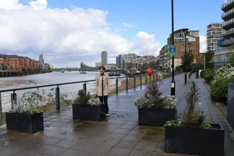 Wandsworth Council Labour councillor Jenny Yates on the Thames Path next to existing planter box arrangements designed to slow bicycle speeds.