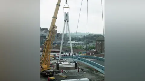 Yorkshire Design Group A crane lifting part of a bridge structure into place.