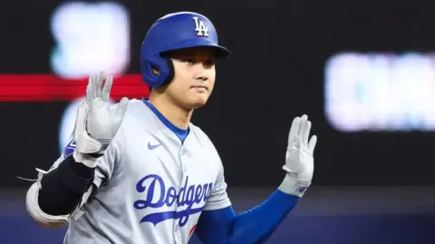 Shohei Ohtani of the Los Angeles Dodgers reacts after hitting a double against the Miami Marlins