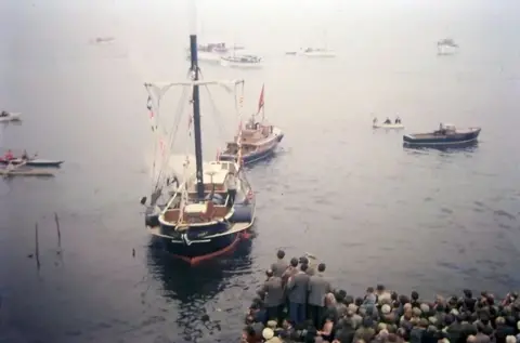 Murray Paterson An old photo of a small steamship which has just been launched with crowds watching from the quayside