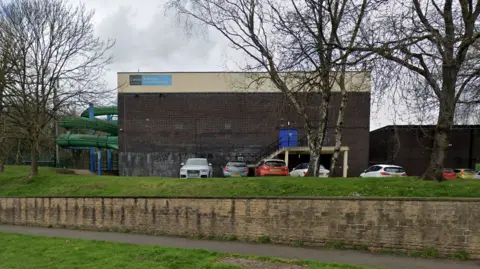 Google A Streetview image of the current leisure centre, an aging brown brick rectangular building with no visible windows.